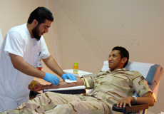 A health care worker with a military blood donor